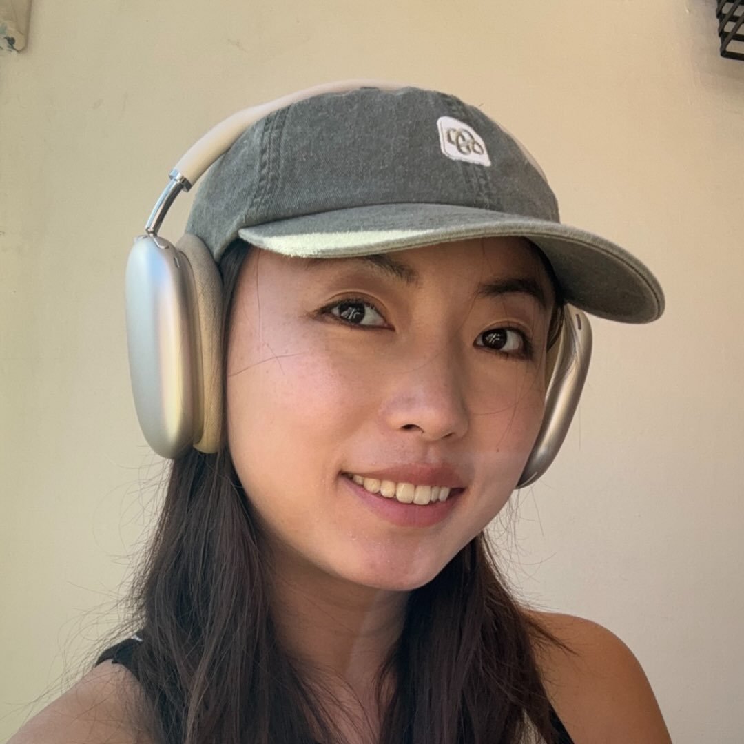 Angel smiling in a green cap and headphones